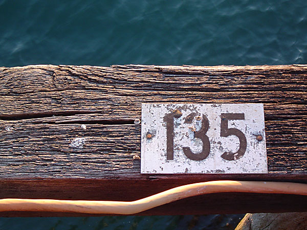 Sign reading 135, on a weathered piece of wood